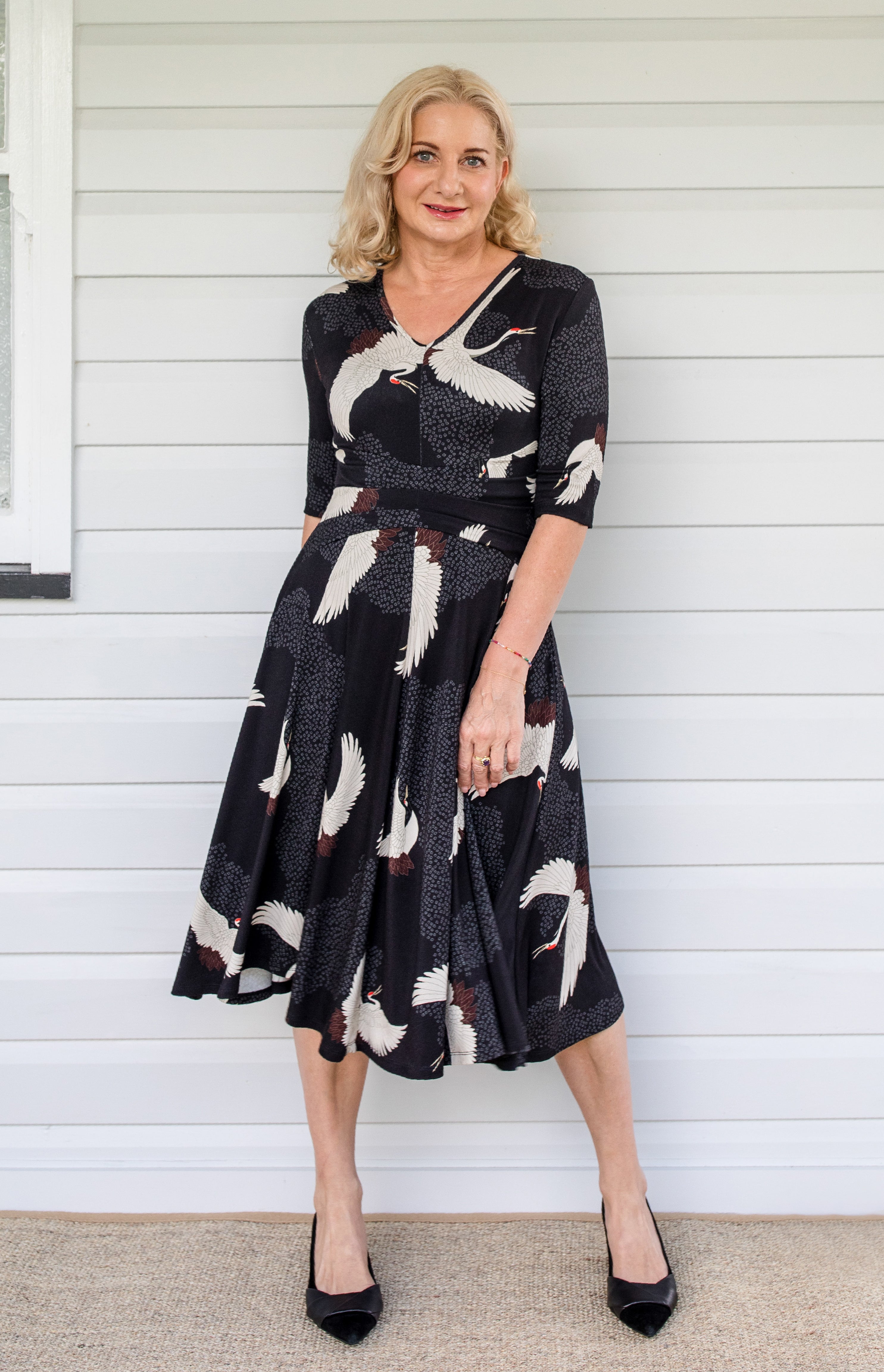 Model wearing Cleo Dress in black Poetry in Motion print – nipped waist and twirly skirt